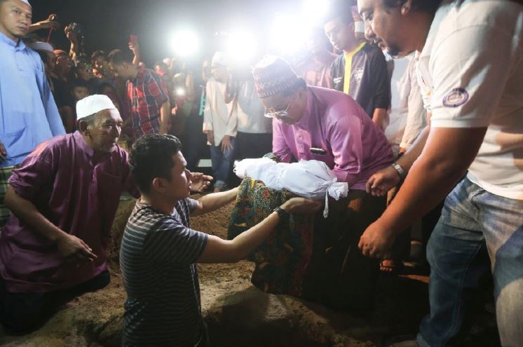 Berita Harian Online Mohd Sufi Naeif Mohd Fauzi mengangkat jenazah anaknya, Adam Rayqal untuk dikebumikan.